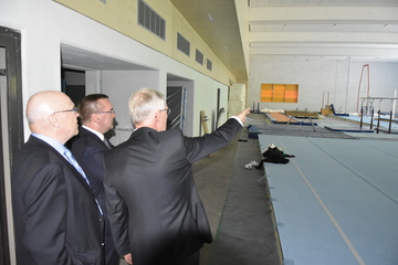Minister Pistorius mit Umbach und Rawe schauen sich den Stand der Erweiterungsarbeiten für die Geräteturn- und Judohalle im Sportleistungszentrum Hannover an
