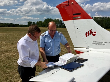 In Amelinghausen lässt sich der Minister vom Feuerwehrflugdienst erklären, wie durch den gezielten Einsatz von Löschflugzeugen Waldbrände eingedämmt werden können.
