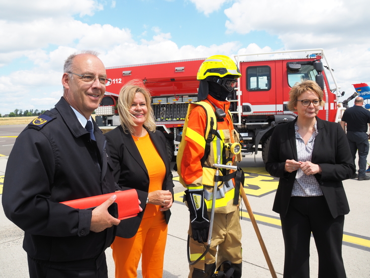 Landesbranddirektor Dieter Rohrberg, Bundesinnenministerin Nancy Faeser und Innenministerin Daniela Behrens begutachten die Feuerwehrkleidung