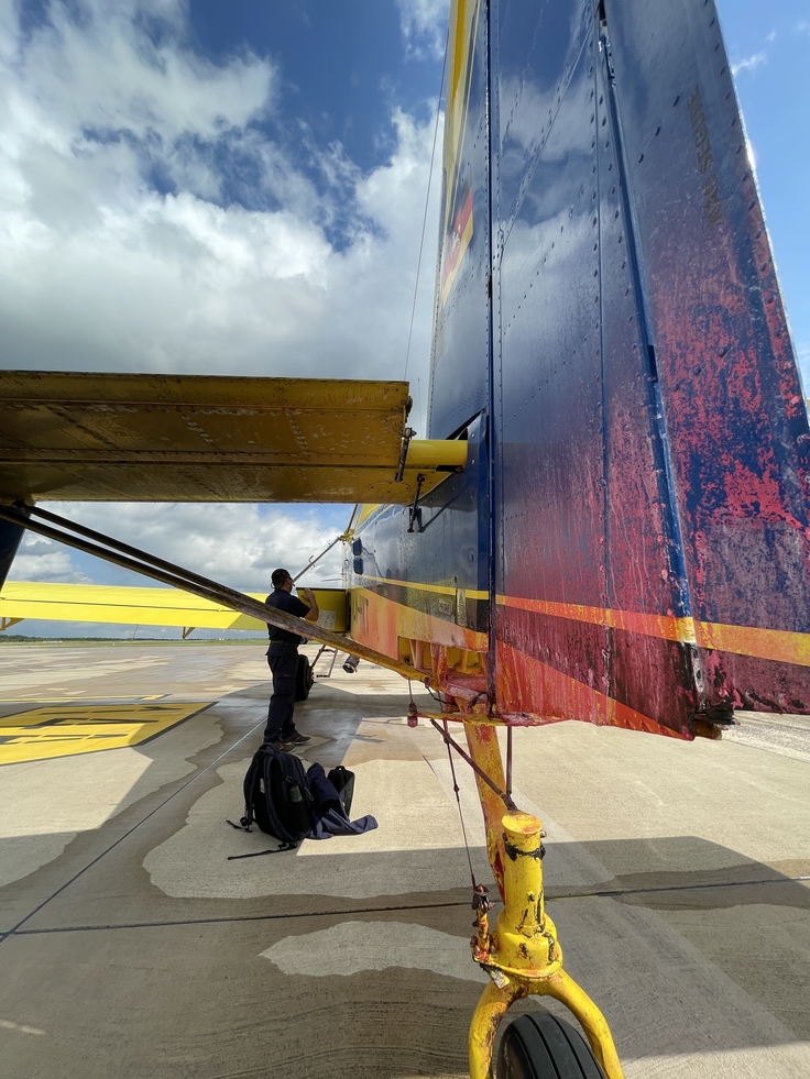 Heckansicht eines Löschflugzeuges mit deutlichen Rückständen des Löschwasserzusatzes